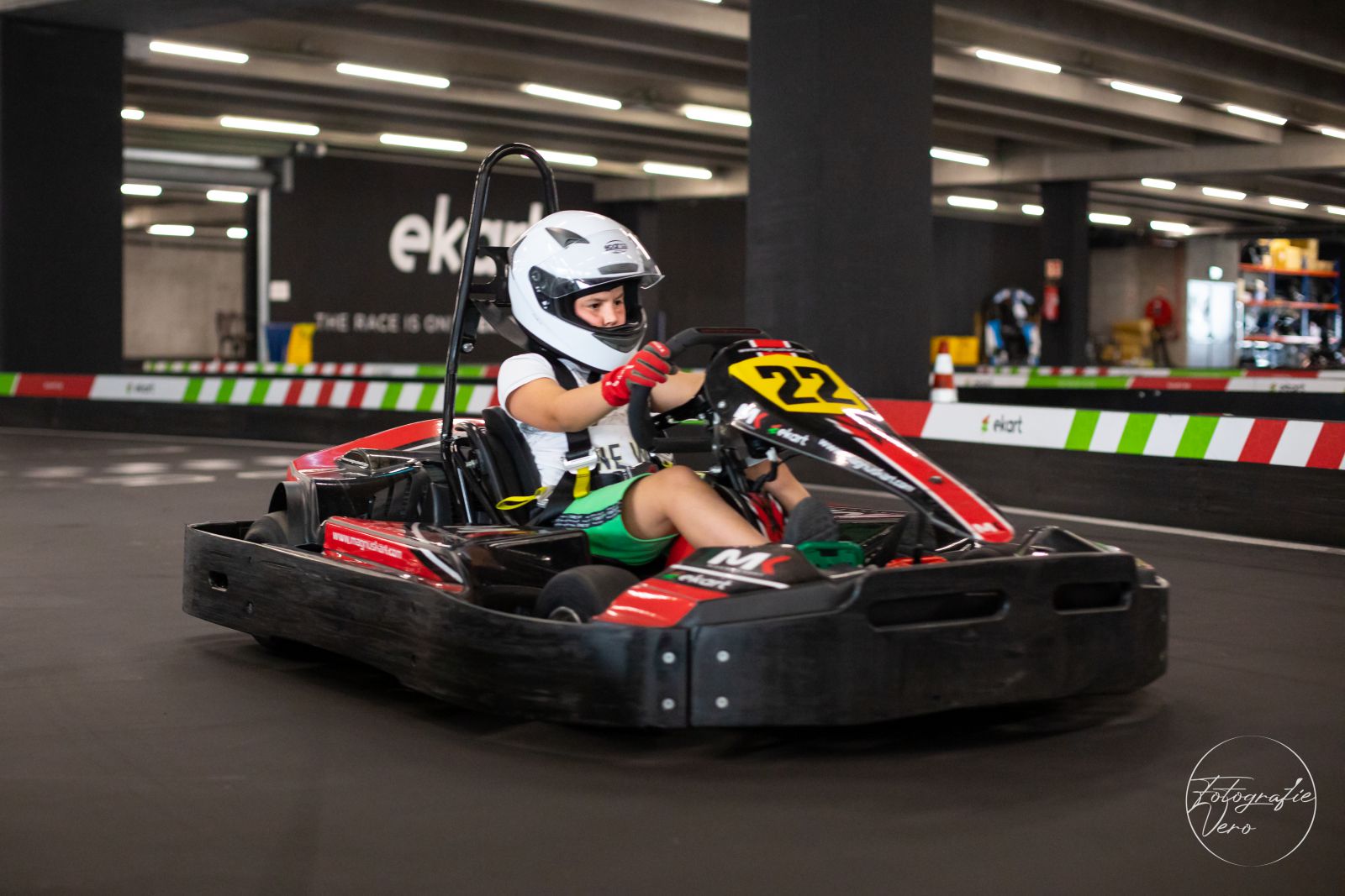 Kind aan het karten op de indoor kartingbaan van E-Kart